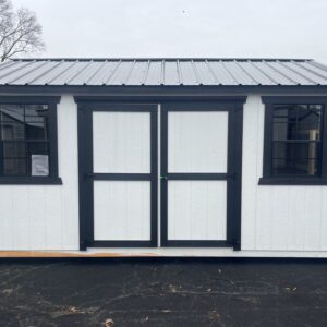 A Frame Shed. White with Black Trim. 2 Windows and a door.